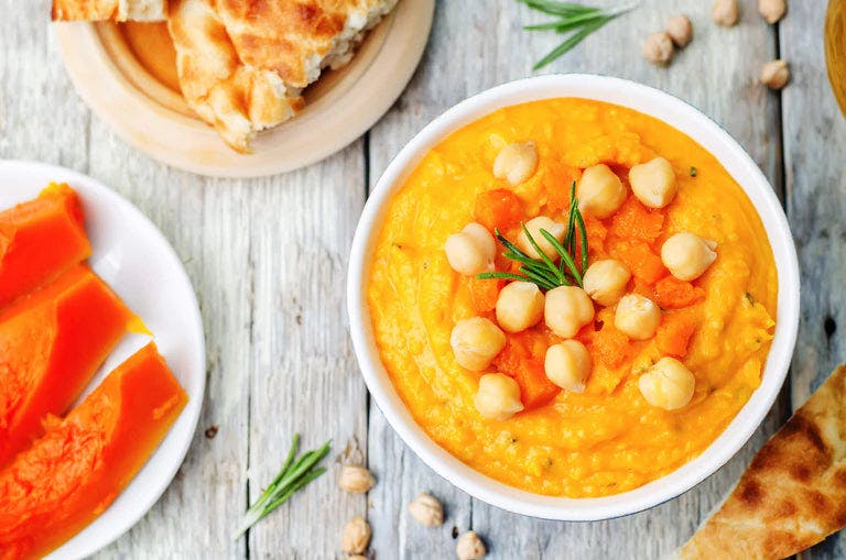 Autumn-themed hummus spread with seasonal vegetables and herbs