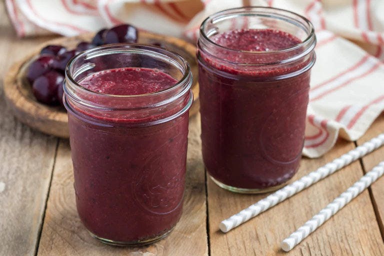 Two glasses of Black Cherry Limeade Delight on a table.