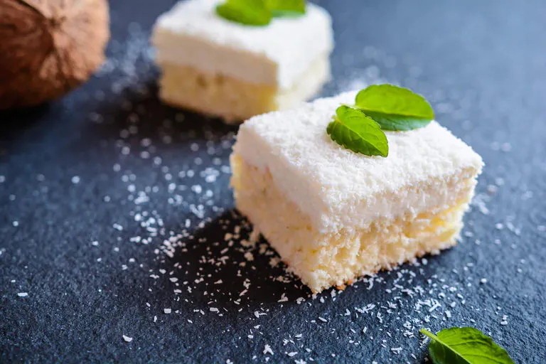 Refreshing coconut lime cocktail cake on a white plate
