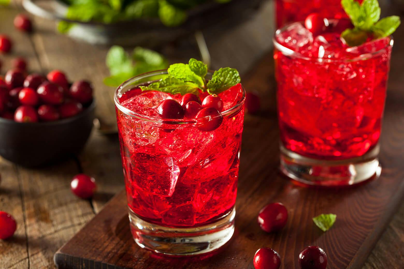 Glass of cranberry vodka with sprig of mint