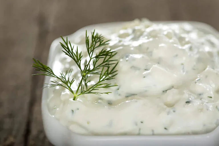 Creamy dill dipping sauce with a sprig of dill