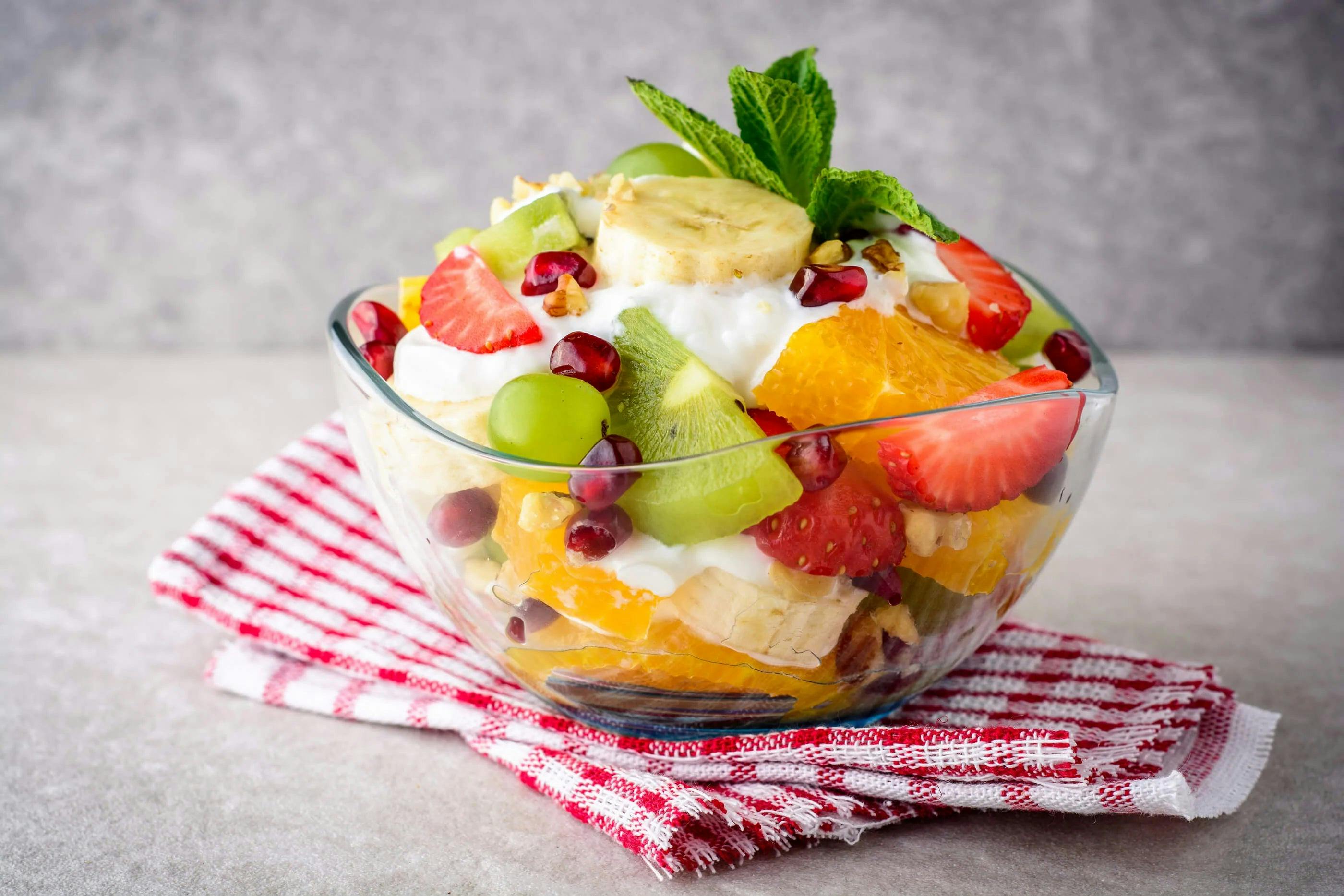 Fresh orange fruit salad in a bowl over gingham napkins