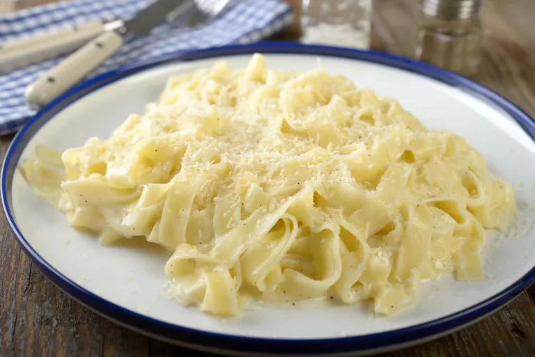 Creamy pasta with cheese on top on a plate