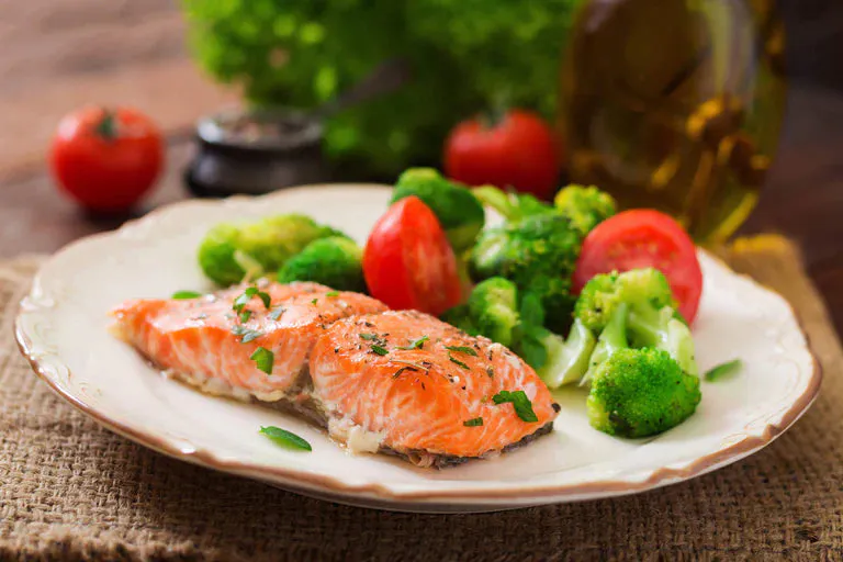 Salmon, broccoli and tomatoes on a plate