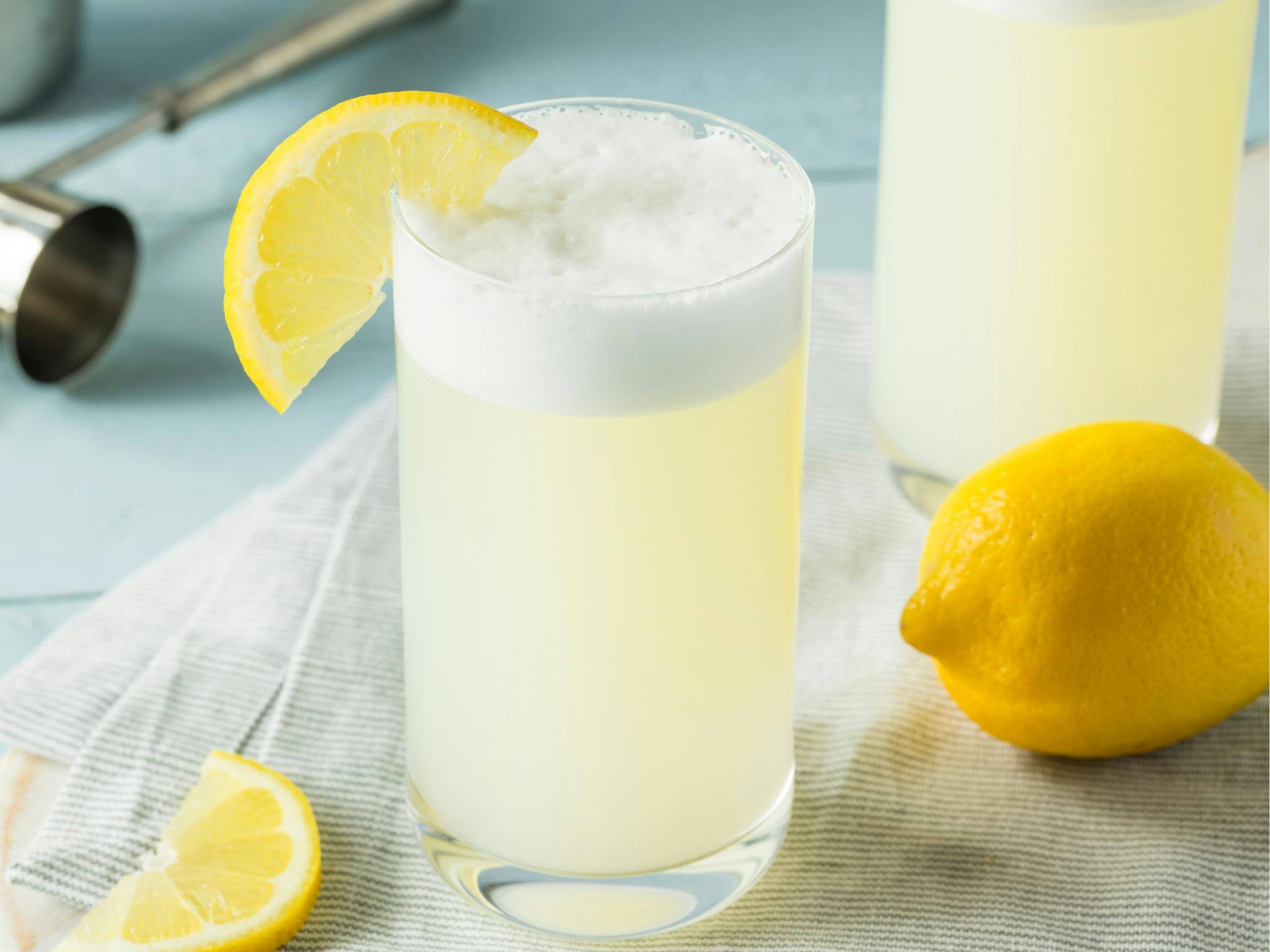 Lemonade cold foam in a glass with lemons on a table.