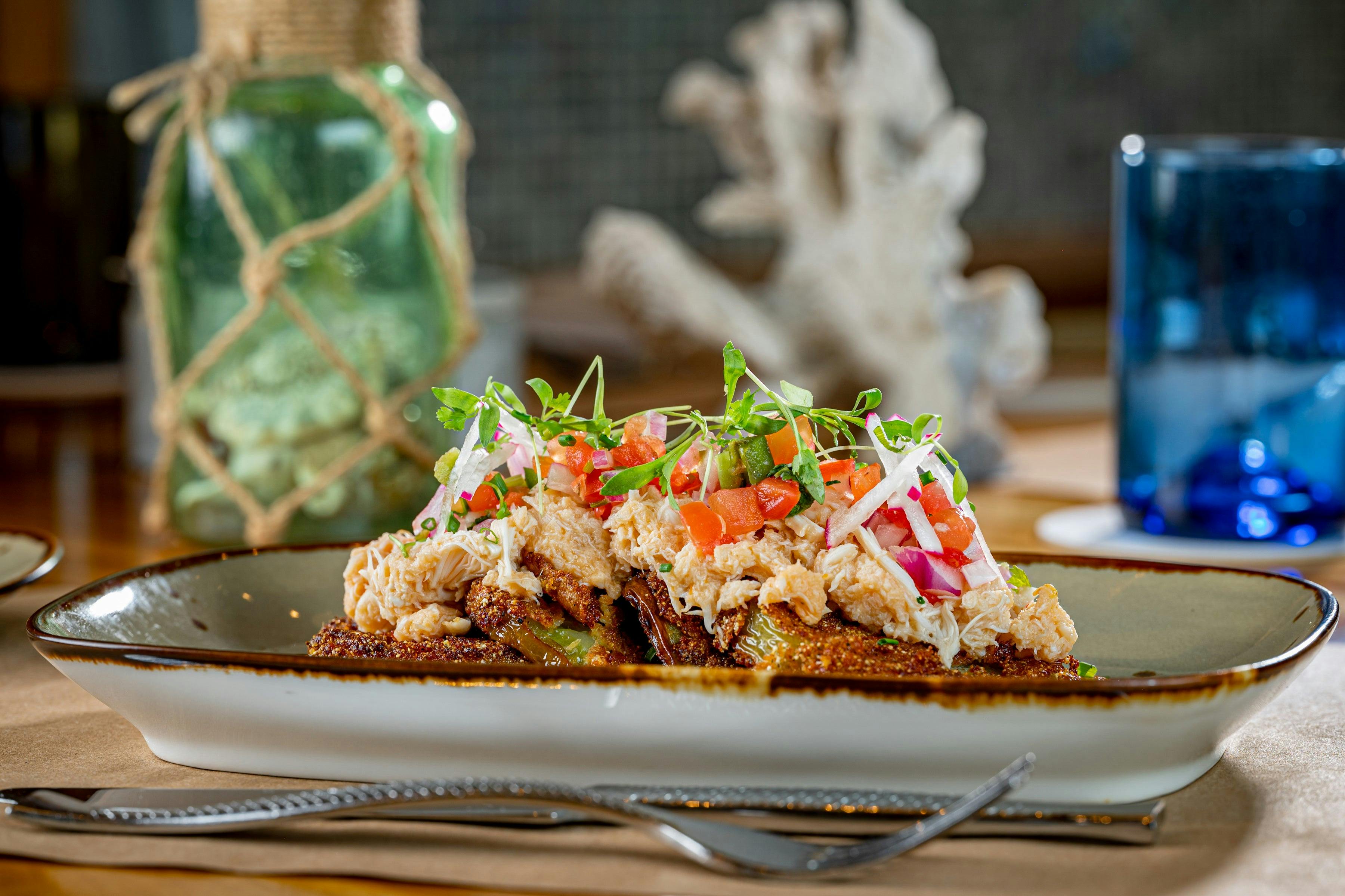 Fried green tomatoes and true remoulade beautifully plated in a dish on a tablescape.