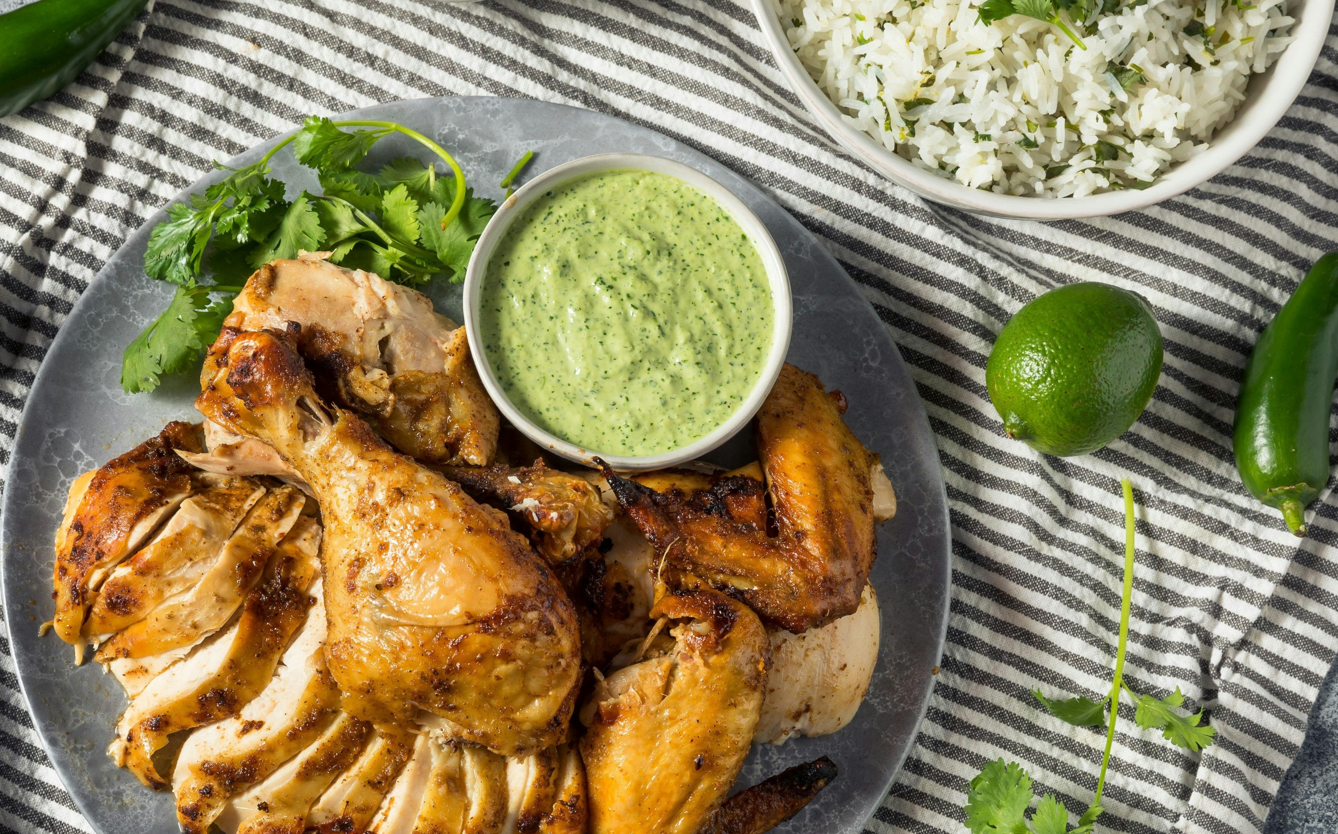 Cooked chicken on plate with green dipping sauce