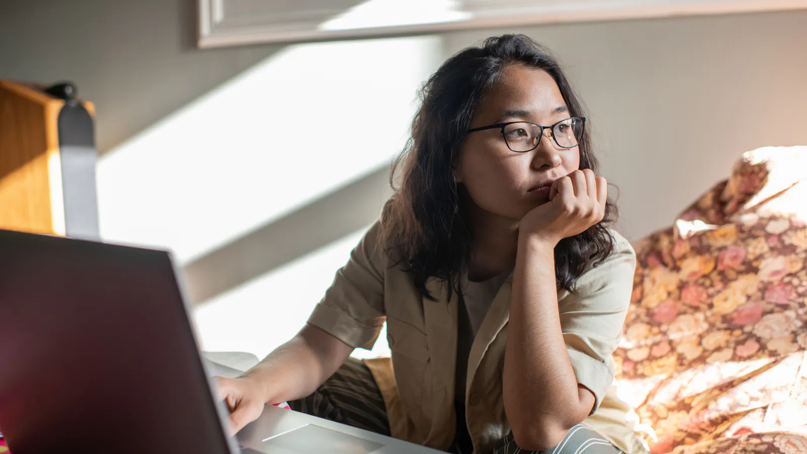 A woman is sitting down looking contemplative.