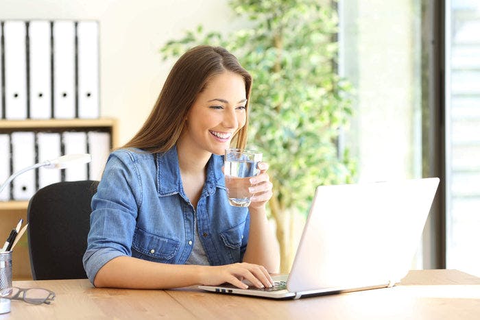 woman smiling while on her computer