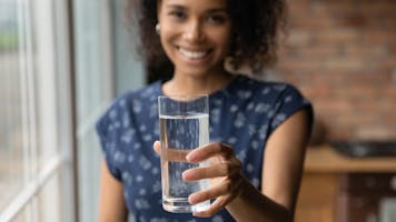 woman holding a glass of water