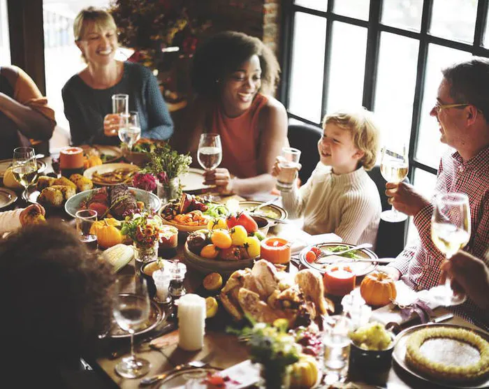 family gathers around the table for thanksgiving