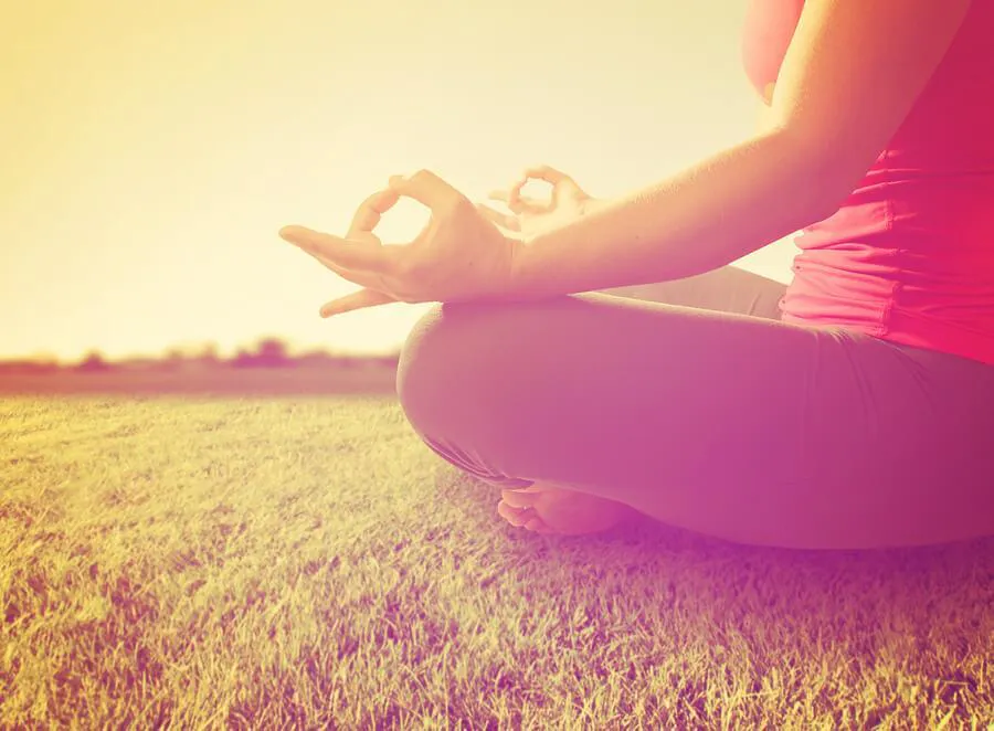 Person meditating outdoors with serene nature backdrop, highlighting meditation benefits