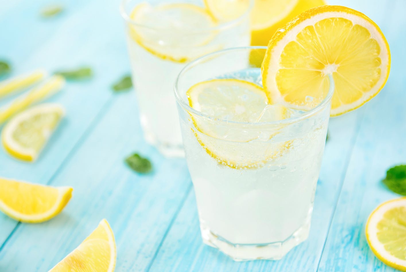 A refreshing glass of Lemon Cake Cocktail served over ice and with lemon slices.