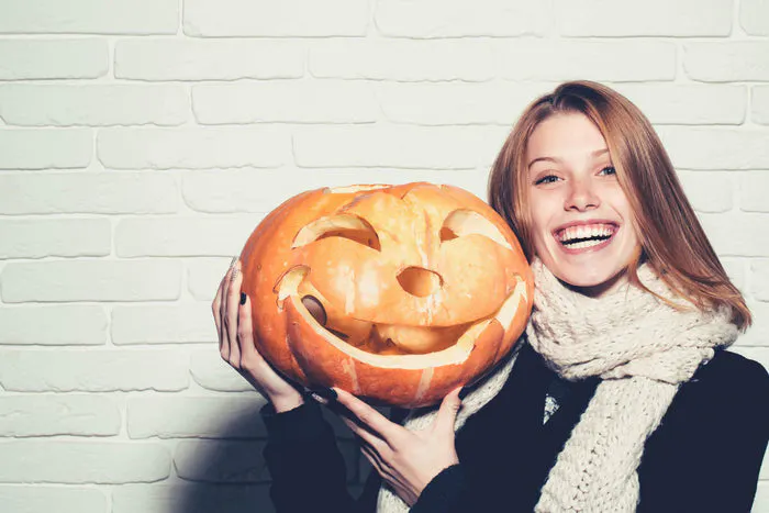 woman holding a jack o lantern