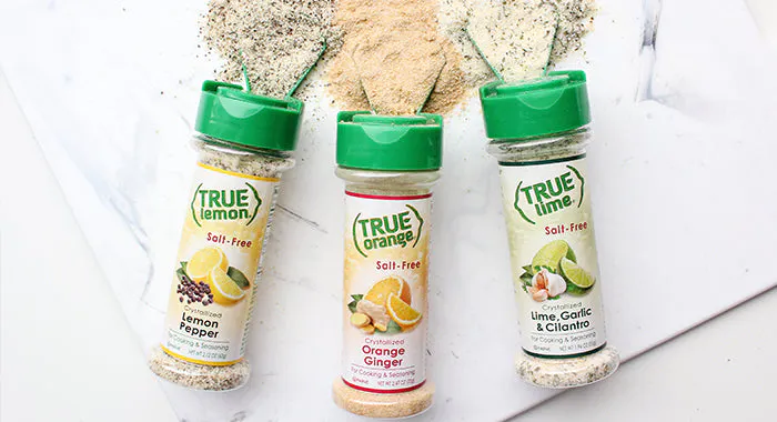 Three True Citrus seasoning shakers on a table