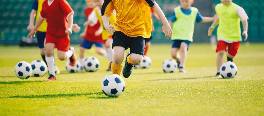 Kids playing soccer on a field.