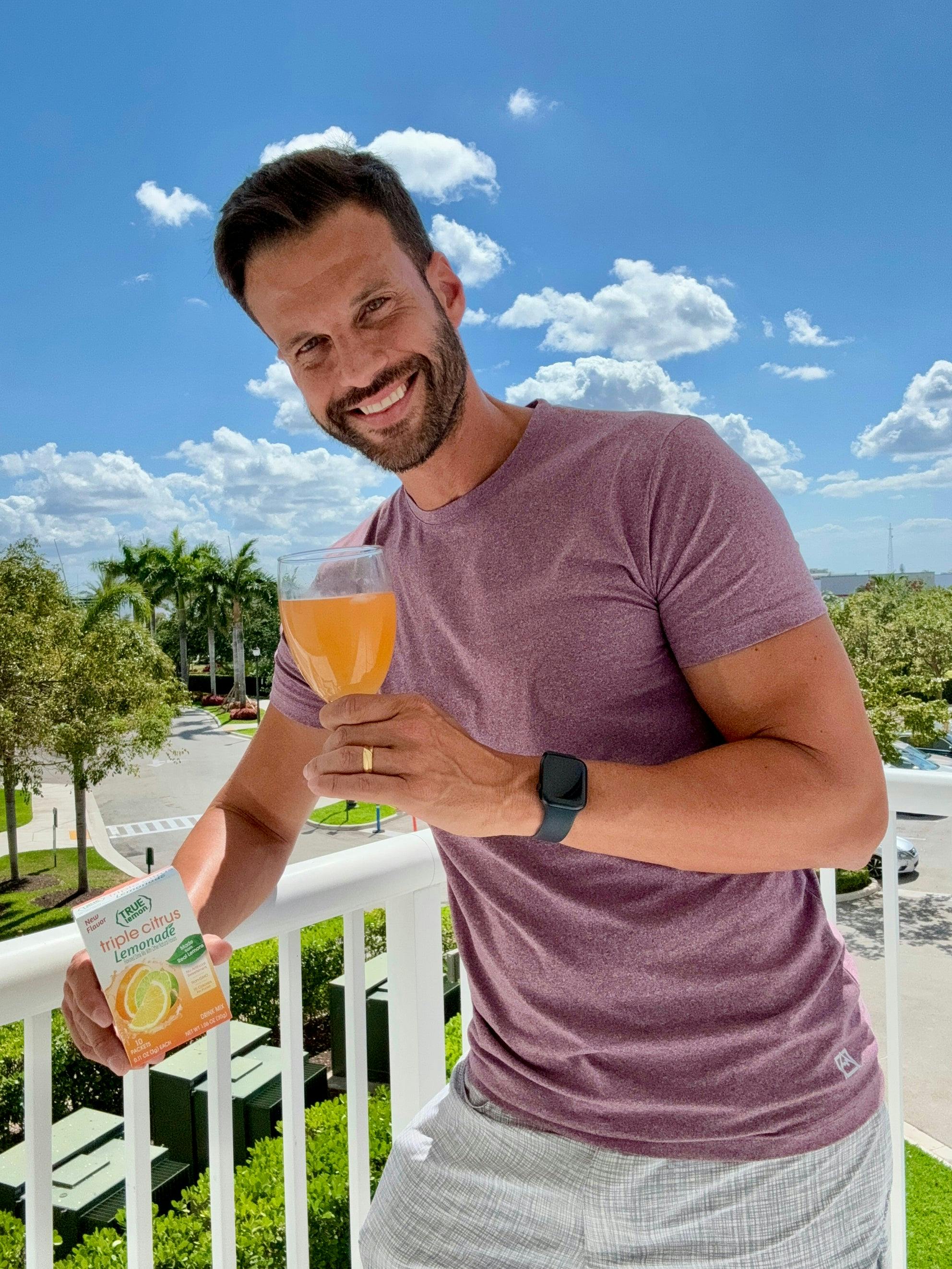 Bright photo of a man with the cocktail in hand