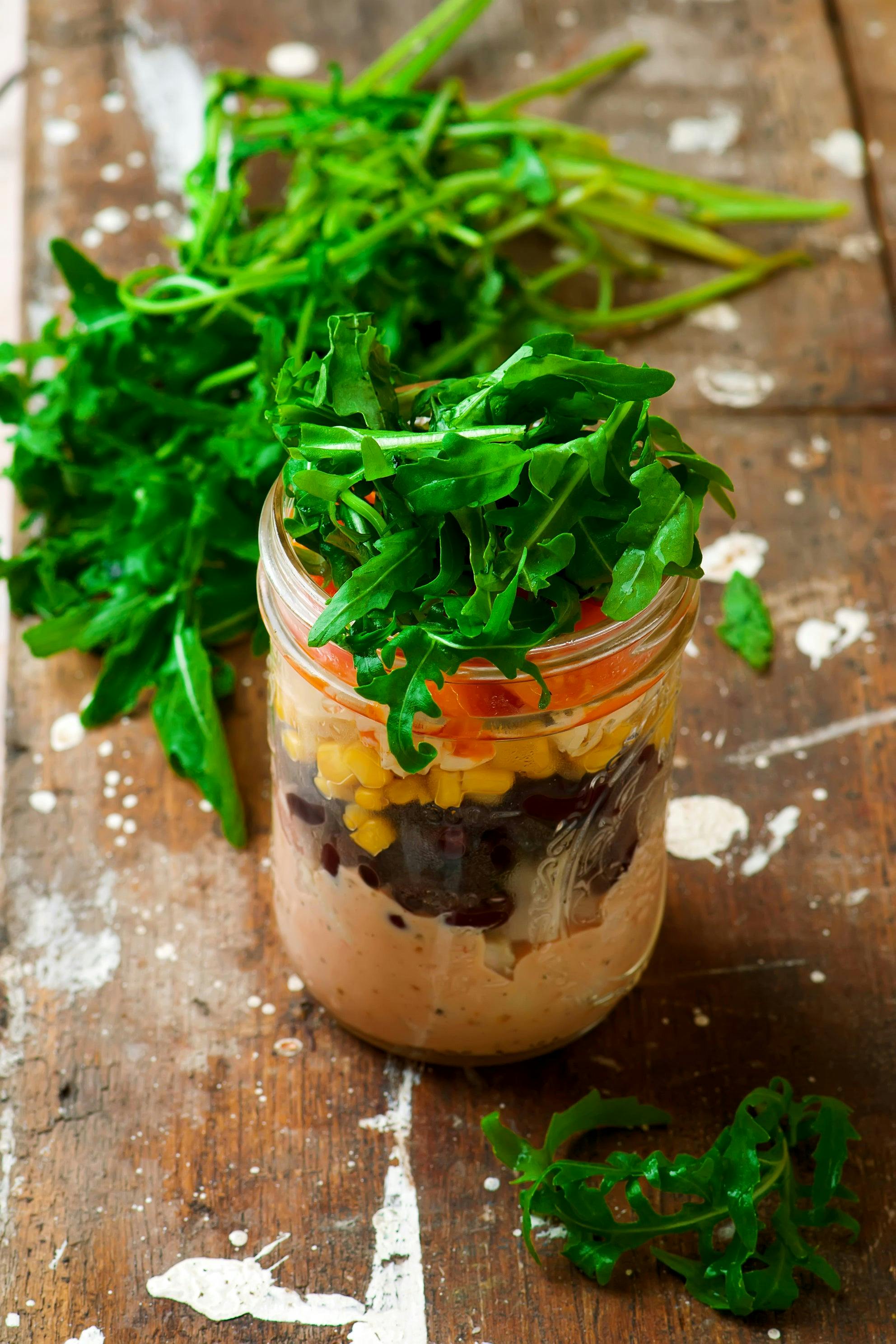 Mason jar stuffed with fresh ingredients and herbs